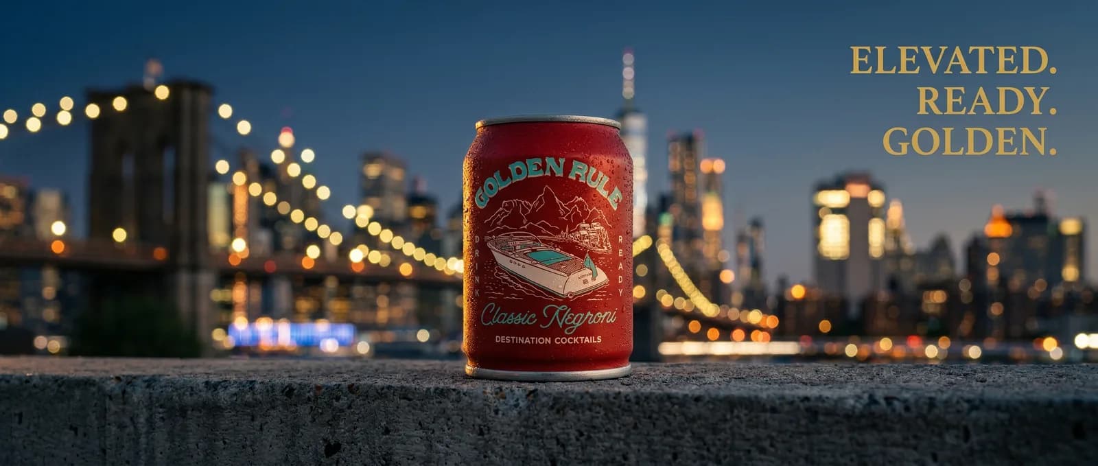 A red can standing on a stone ledge with a lit bridge and a city skyline behind it at dusk, in a wide banner shape with three words of copy on the right